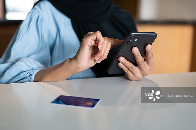 女人在桌子上用智能手机和信用卡图片素材