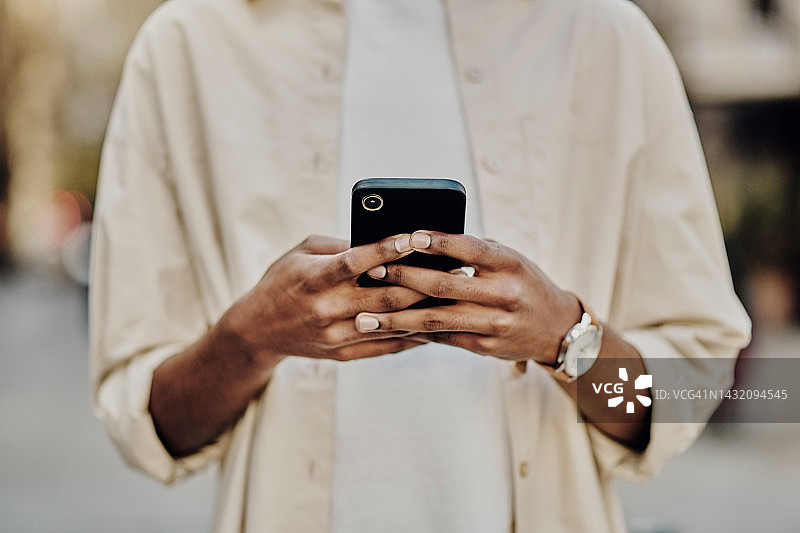 在城市中，用手机放大双手进行通信、社交或社交媒体。联系我们的男人使用科技、智能手机或技术，通过5g搜索、互联网或网站进行应用程序更新图片素材