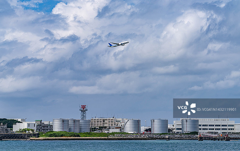 飞机在日本那霸市海滩上空飞行图片素材