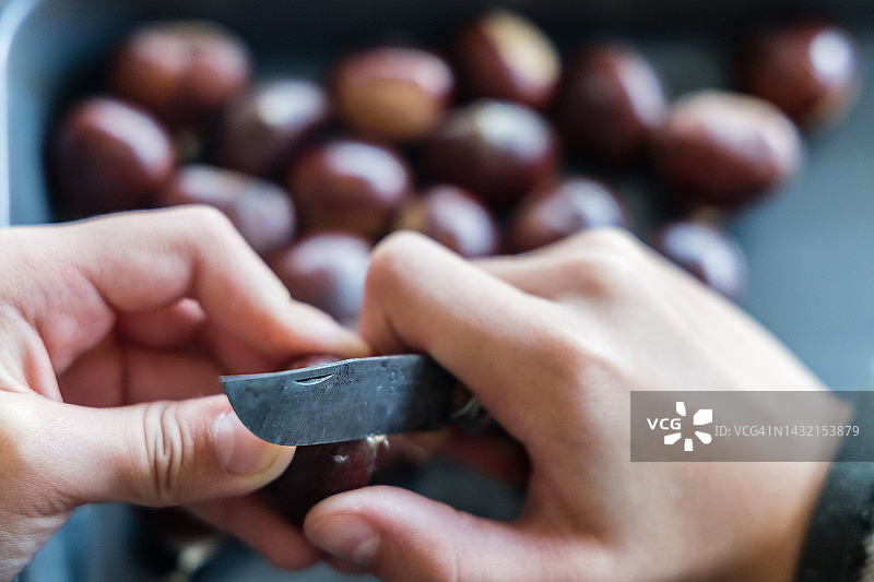 孩子在烤栗子前剥栗子图片素材