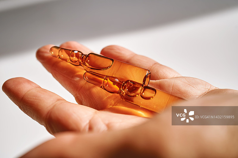 女人手中的两支玻璃安瓿图片素材