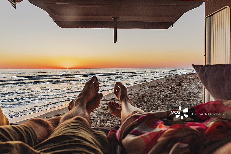 日落时分情侣在沙滩房车内享受图片素材