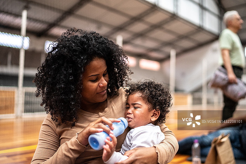 难民母亲在社区中心的避难所喂养婴儿图片素材