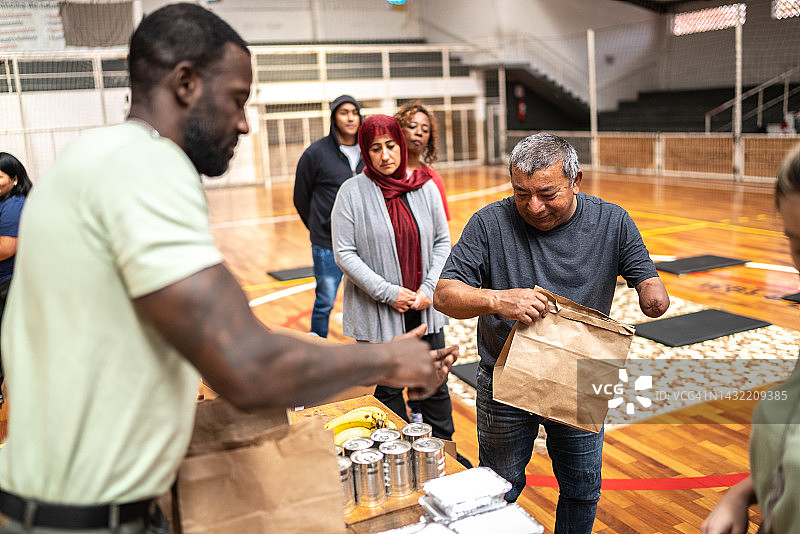 士兵在社区中心向残疾中年男人提供食物图片素材