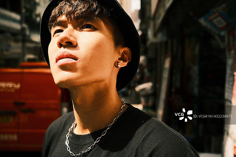 阳光下的时尚亚洲青年男子图片素材