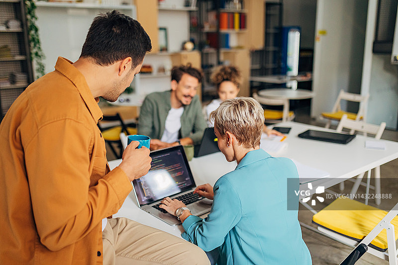 一小群学生学习编写程序，IT专家一边喝咖啡一边检查他们的编码技术图片素材
