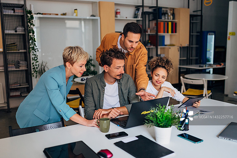 讨论新项目的程序员群体。他们看着笔记本电脑屏幕并测试代码图片素材
