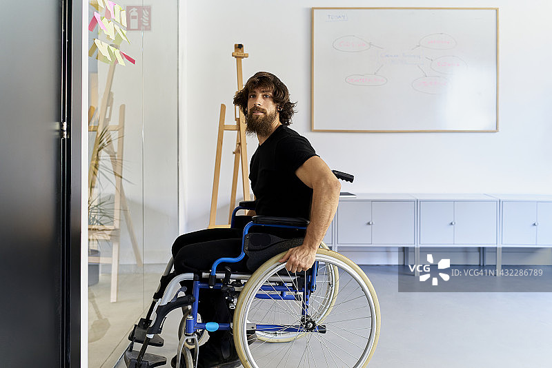 坐在轮椅上的黑衣白人男子图片素材