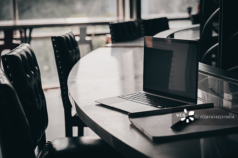 用户在开放式办公室内使用笔记本电脑图片素材