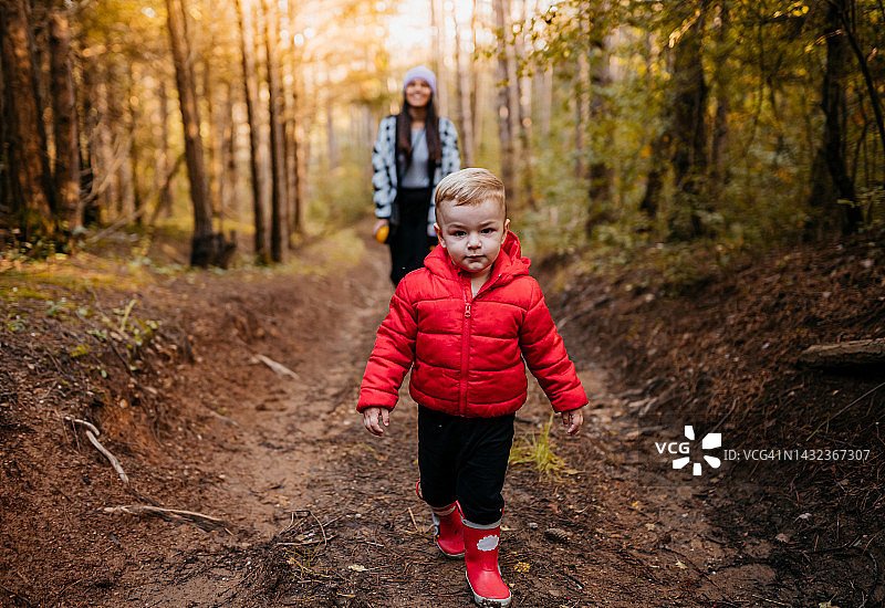 小男孩和年轻的妈妈在森林里散步图片素材
