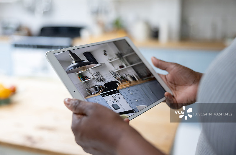 女人用平板电脑查看家中监控摄像头图片素材