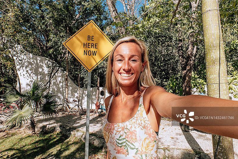 女人与“活在当下”标牌自拍图片素材