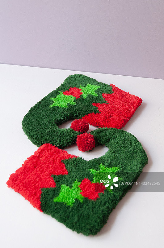 圣诞节装饰品，圣诞老人精灵袜子或纺织地毯制成的靴子，用于装饰家居，粉红色背景图片素材