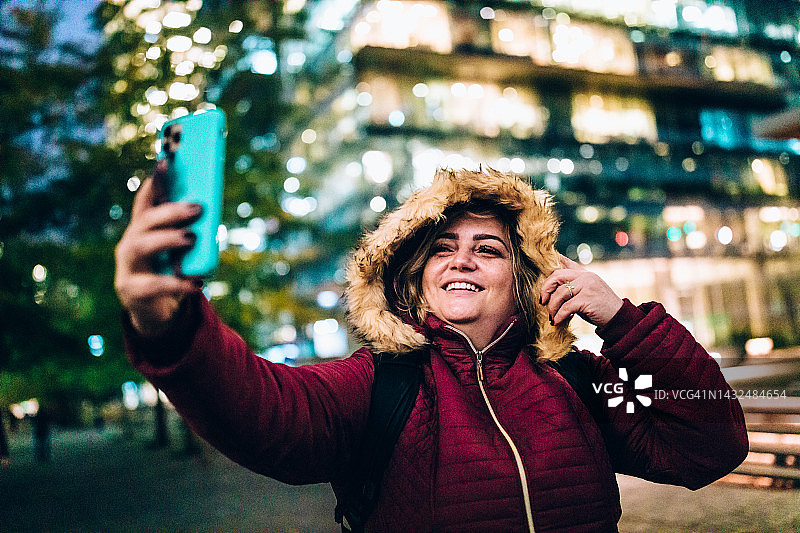 女人在夜晚用手机自拍图片素材