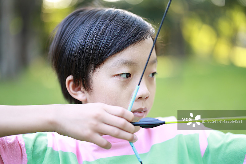 小男孩在公园射箭图片素材