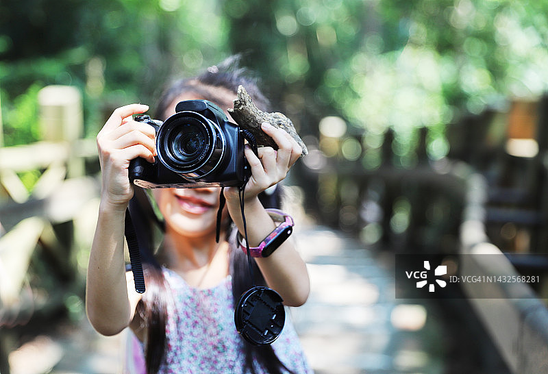 亚洲女孩用数码相机拍照图片素材