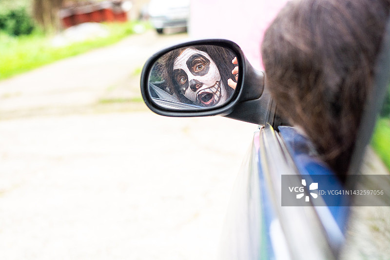 伪装的女人在汽车侧视镜中的倒影图片素材