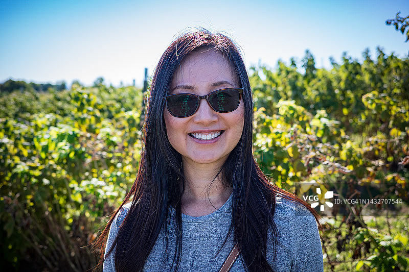 面带微笑的中年亚洲女子，佩戴太阳镜图片素材