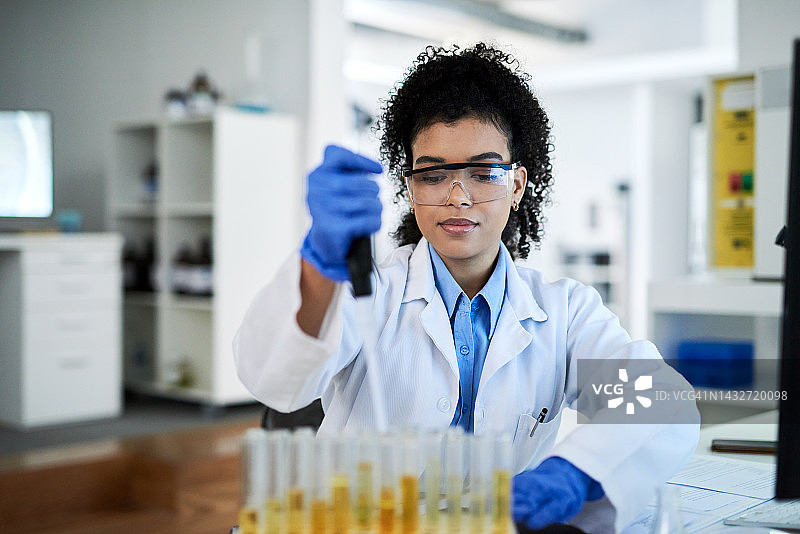 在实验室用试管进行化学实验的黑人女科学家图片素材