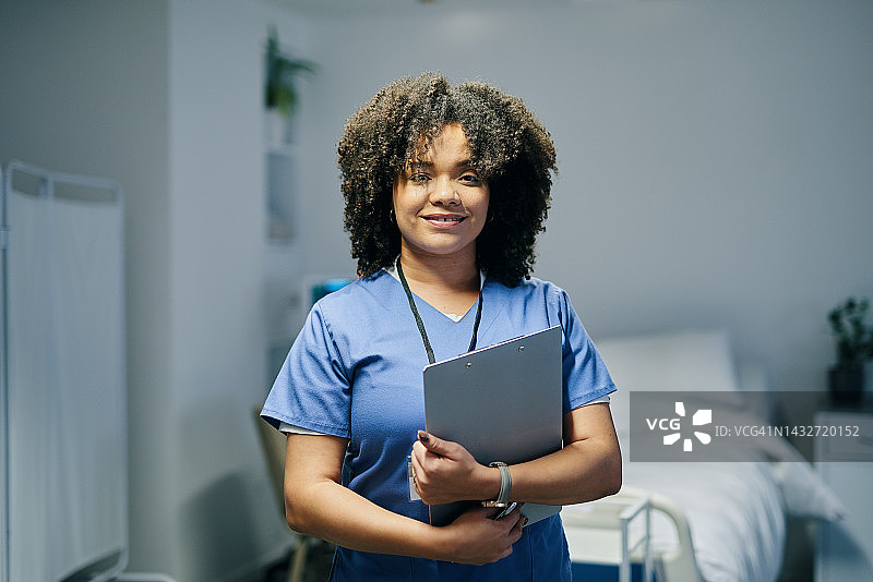医院里，黑人妇女和护士在床边合影，有病人护理处方记录。专业、有条理的非洲护士，手拿剪贴板，在医疗机构微笑。图片素材