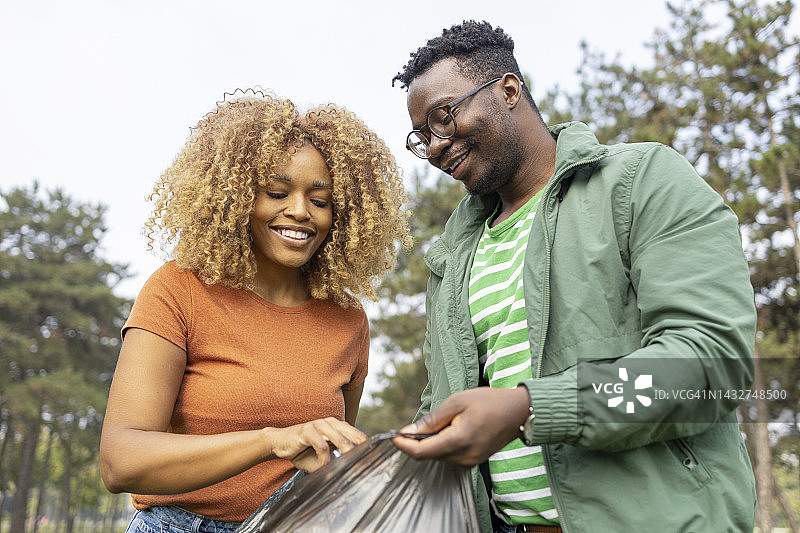 快乐的男女志愿者一起捡垃圾图片素材