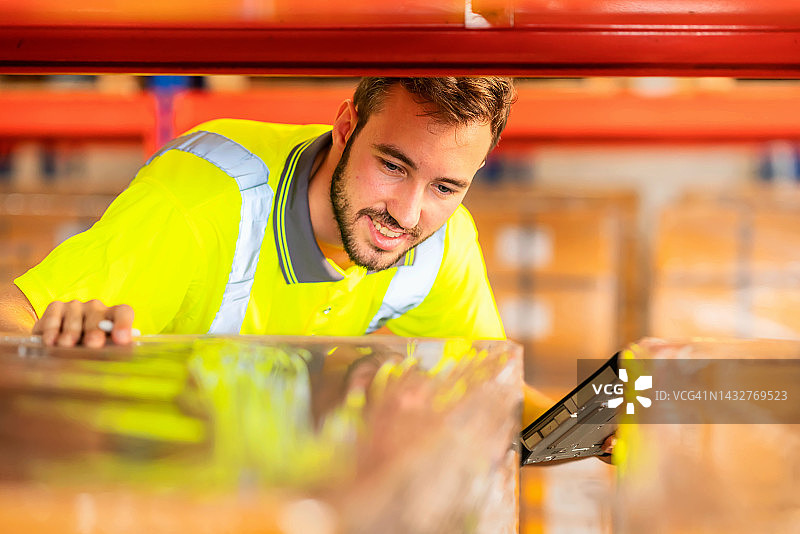 仓库主管手持发货计划，在大型仓库中使用平板电脑检查库存水平并更新，按需供应图片素材