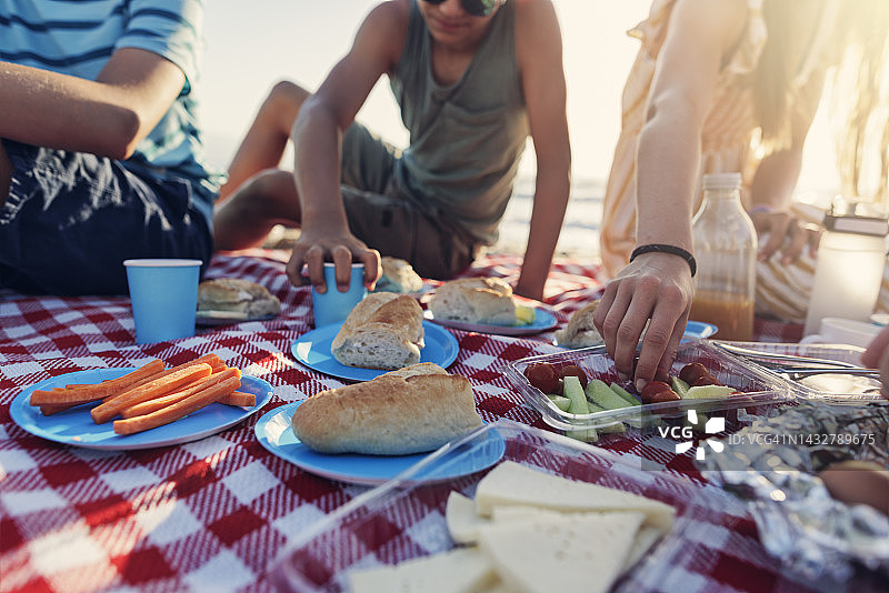 在海滩上享用夏季野餐早餐的家庭图片素材