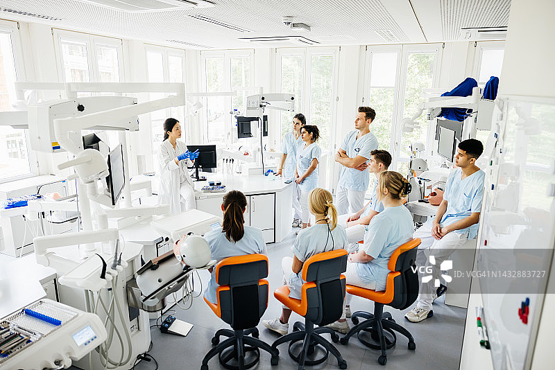 牙科学生在外科套件中听老师讲课图片素材