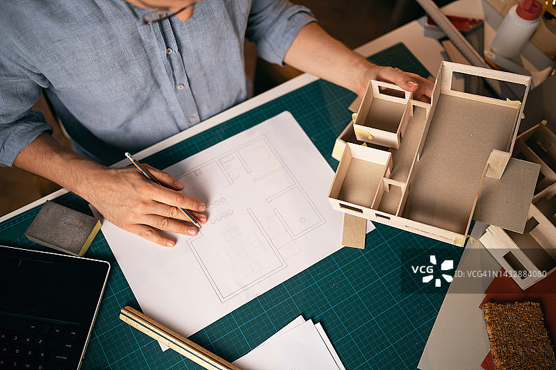 建筑师参考蓝图制作建筑模型（仅显示局部）图片素材