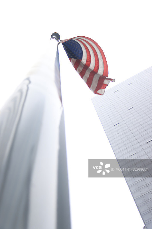 白色天空下的旗杆上的美国国旗图片素材