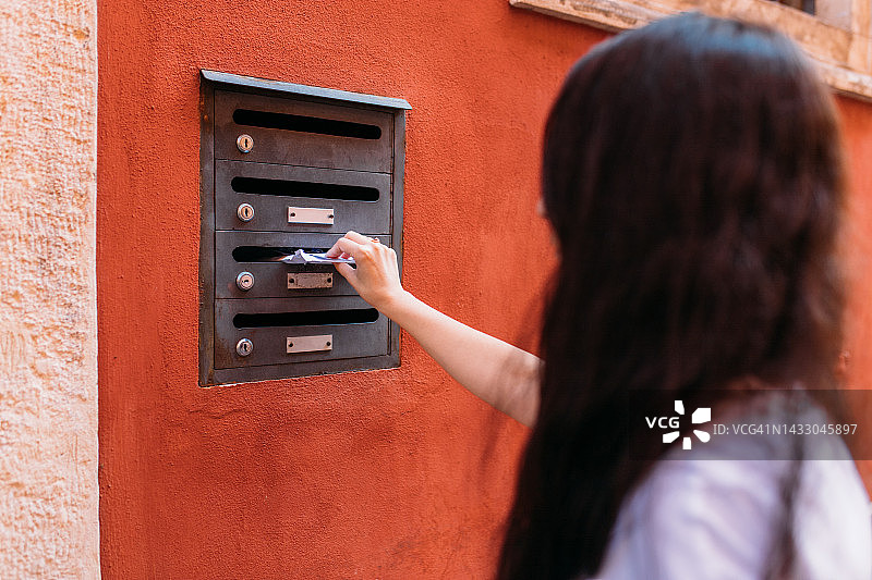 女人从邮箱里取出她的邮件图片素材