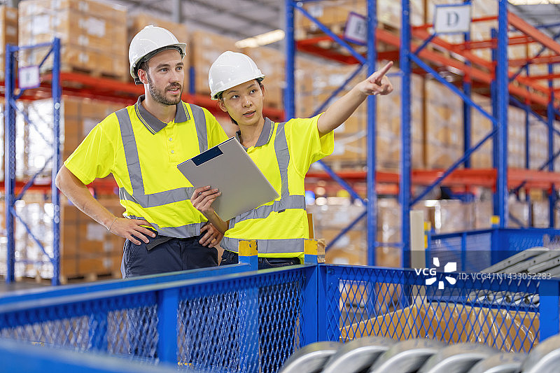 仓库工人讨论工厂仓库发货计划图片素材