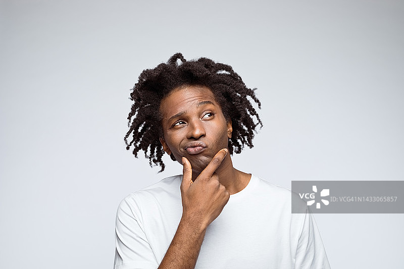 穿着白色T恤的困惑男人肖像图片素材