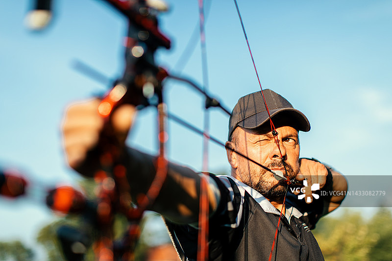 使用假肢手臂在户外射箭的男人图片素材