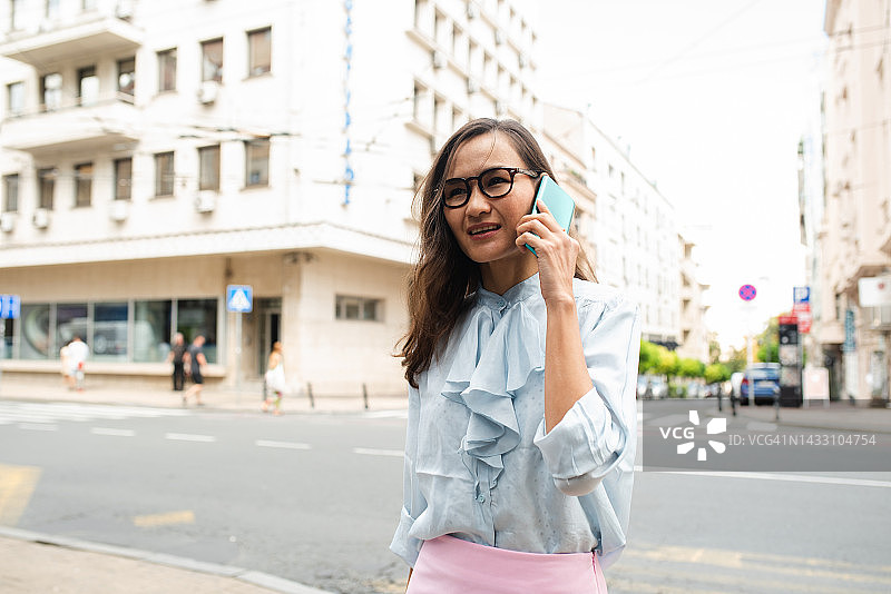 移动中打电话的漂亮亚洲女子肖像图片素材
