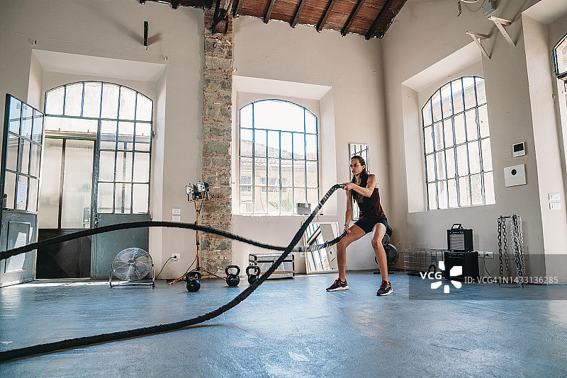 女子在健身房用绳子做运动图片素材