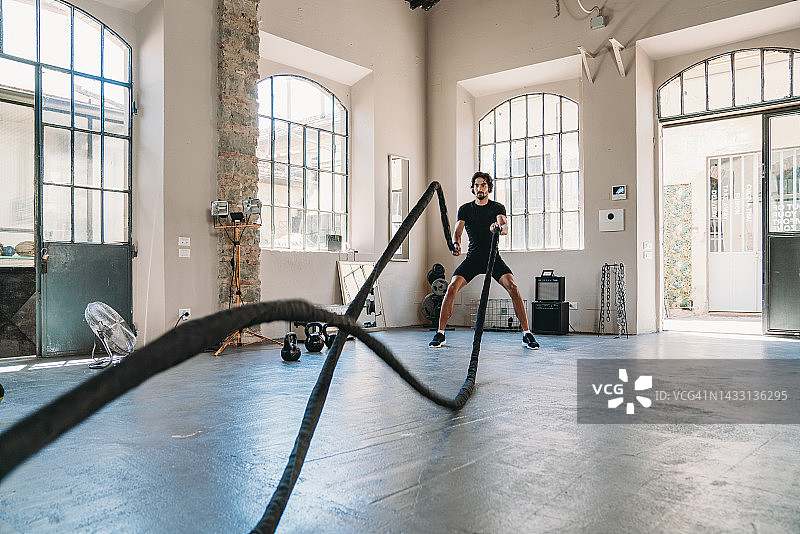 男子在健身俱乐部用绳子训练图片素材