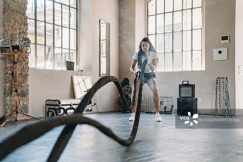 女子在健身房用绳子做运动图片素材