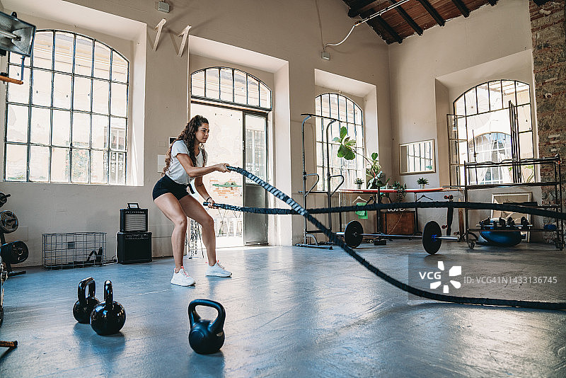 女子在健身房用绳子做运动图片素材