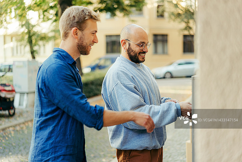 两个男人一起打开新房的前门图片素材