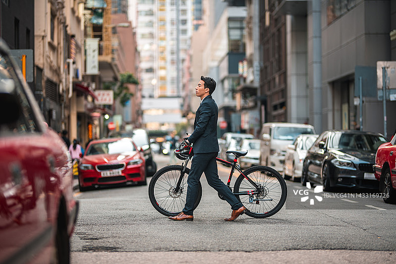 城市中骑自行车通勤的年轻亚洲男性创业者图片素材