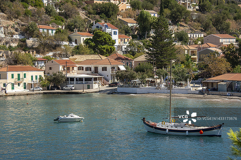 希腊凯法利尼亚岛阿索斯村，翠绿色波光粼粼的海湾中停泊着白色船只图片素材