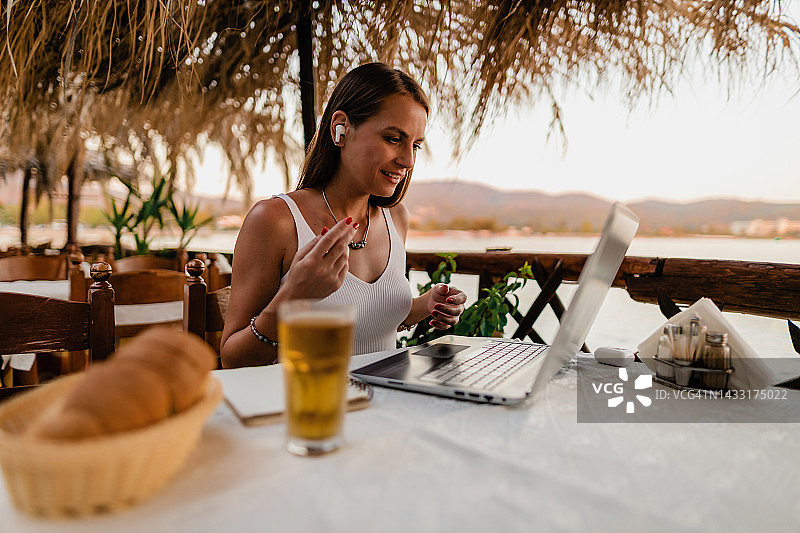 女人在餐厅用笔记本电脑上网课图片素材