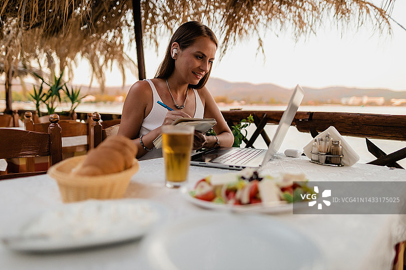女人在餐厅用笔记本电脑上网课图片素材