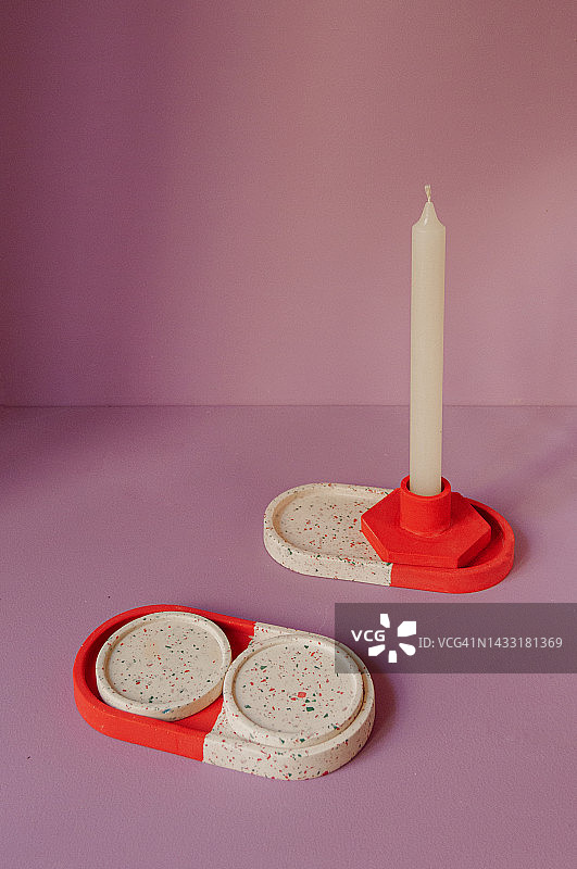 紫色摄影背景中用于圣诞装饰的红色和白色烛台、托盘和杯垫特写图片素材
