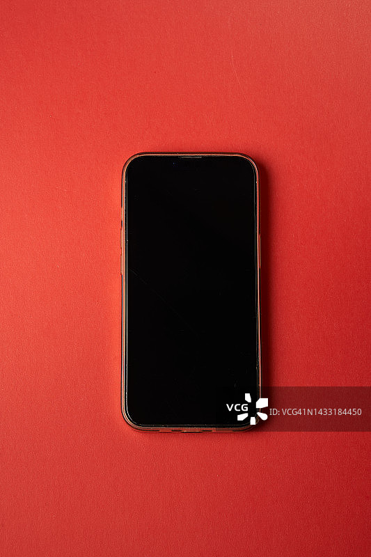 红色背景上的黑色智能手机样机，顶部平铺留白图片素材