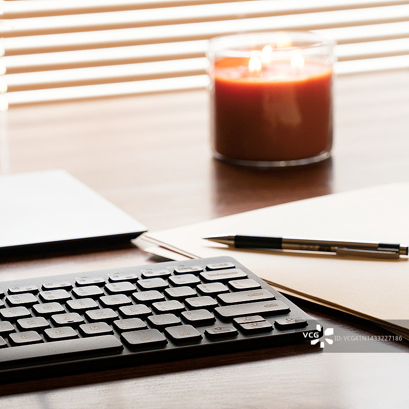 在电脑旁和点燃的蜡烛一起安静工作图片素材