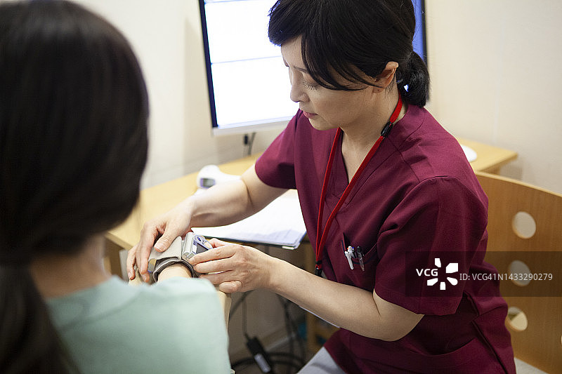 亚洲医生在诊所为病人测量血压图片素材