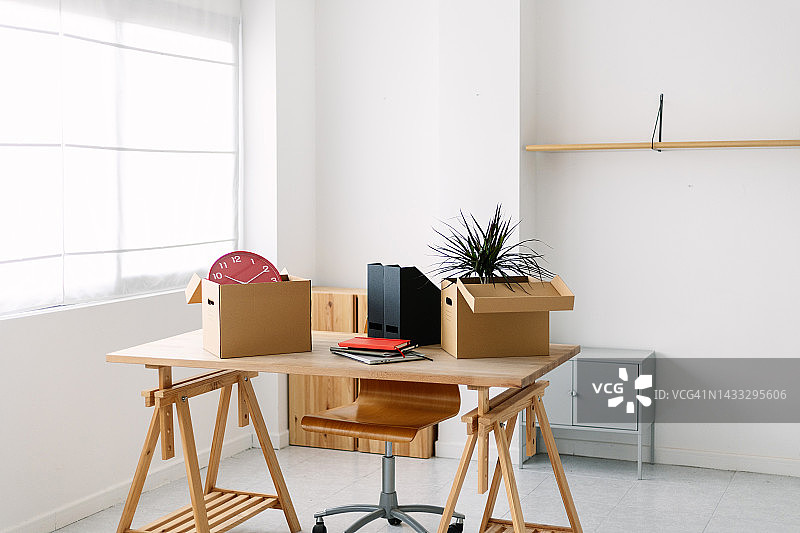 空房间里的家具和搬家纸箱：具有现代办公桌的全新商业概念图片素材