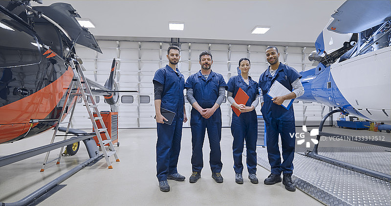 一群机械师站在直升机旁图片素材